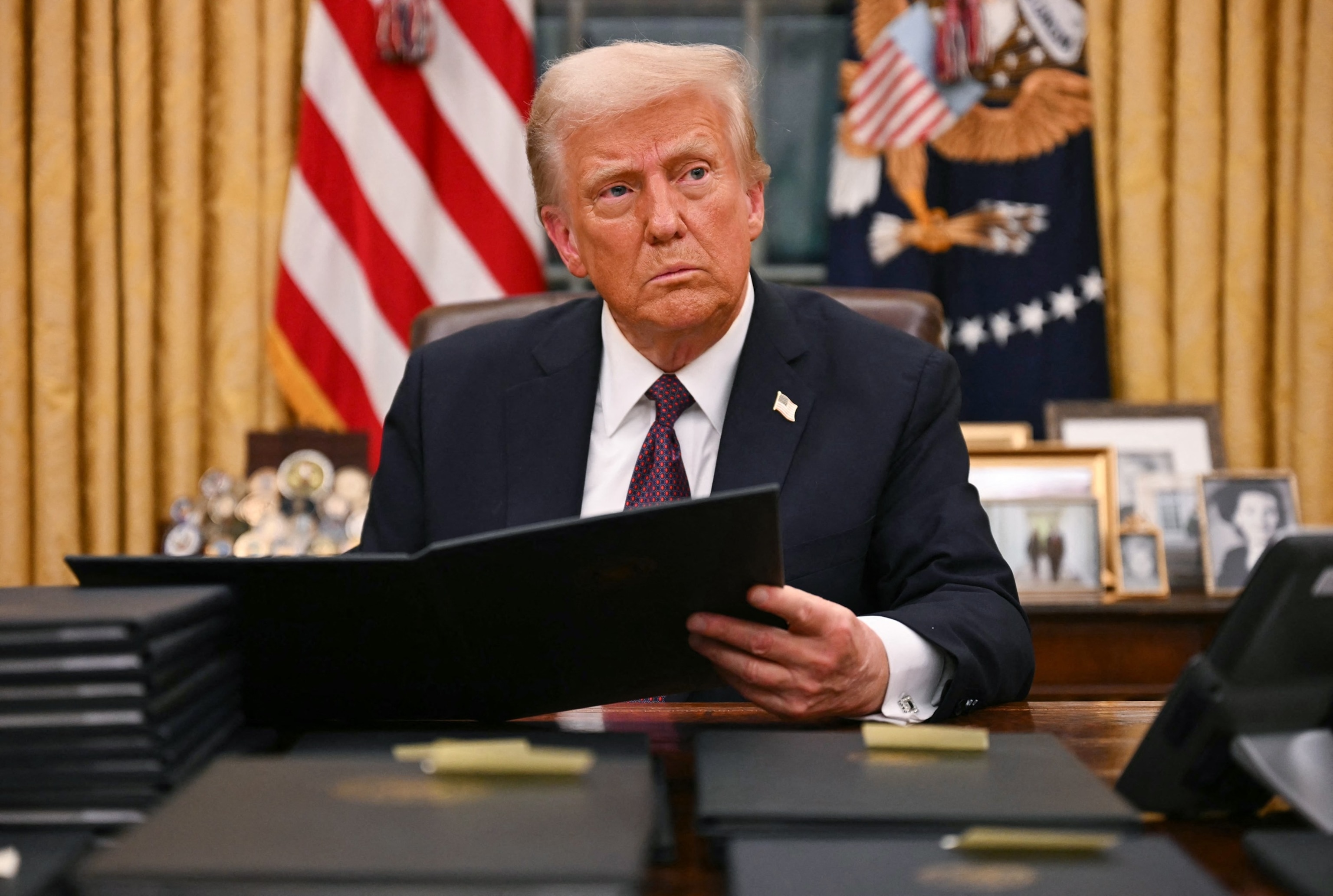 PHOTO: President Donald Trump signs an executive order for pardons on January 6 offenders in the Oval Office of the White House in Washington, Jan. 20, 2025.