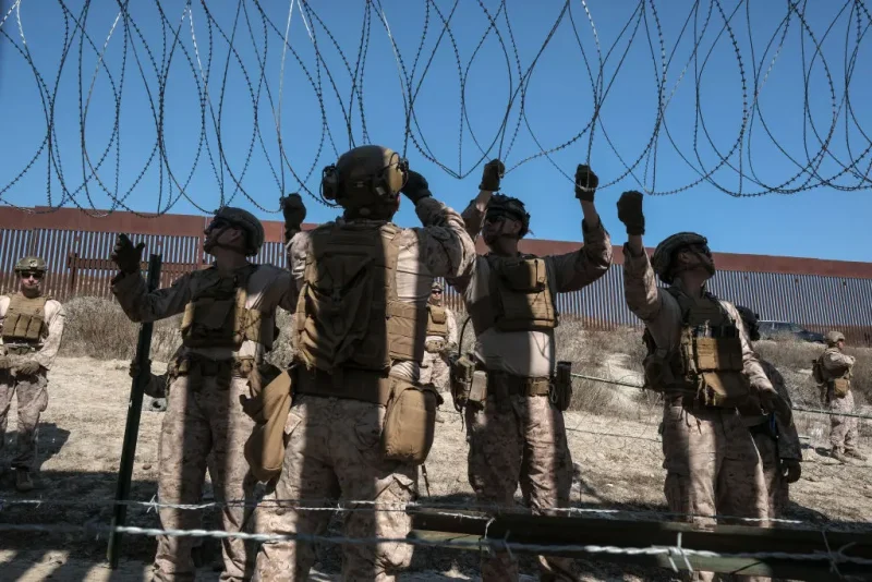 TOPSHOT - US Marine Corps deployed at the southern border in San Diego, reinforce the US-Mexico border wall as pictured from Colonia Libertad in Tijuana, Baja California state, Mexico on February 5, 2025. (Photo by Guillermo Arias / AFP) (Photo by GUILLERMO ARIAS/AFP via Getty Images)