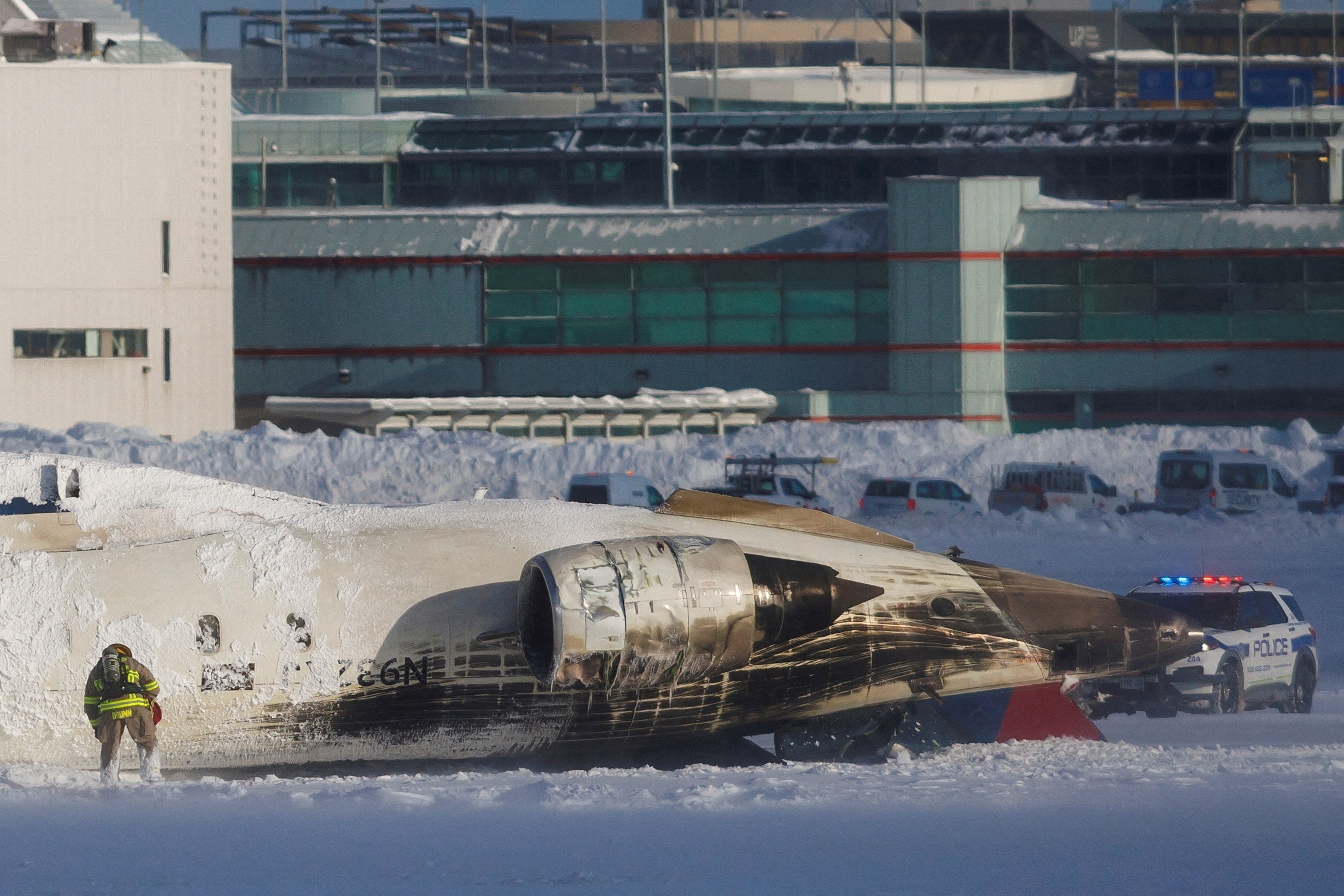 PHOTO: An emergency responder works around an aircraft on a runway, after a plane crash at Toronto Pearson International Airport in Mississauga