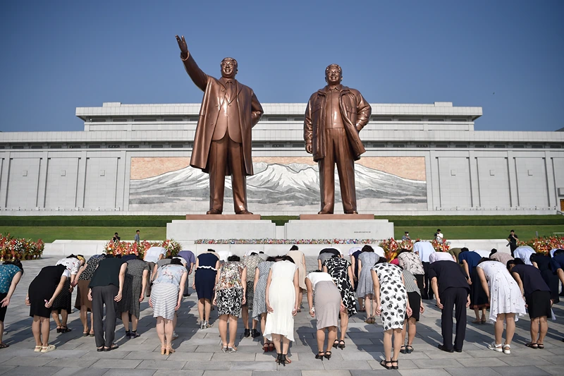 TOPSHOT - People pay their respects before the statues of late North Korean leaders Kim Il Sung and Kim Jong Il at Mansu Hill as North Korea marks its 79th National Liberation Day, commemorating the end of Japanese colonial rule at the end of World War II, in Pyongyang on August 15, 2024. (Photo by KIM Won Jin / AFP) (Photo by KIM WON JIN/AFP via Getty Images)